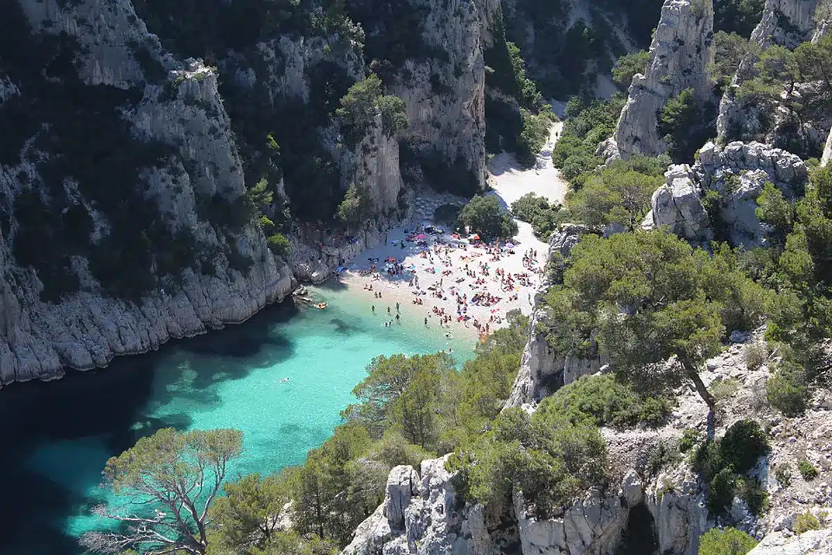 Plage animée avec des baigneurs profitant des eaux claires de la calanque d'En-Vau à Marseille.