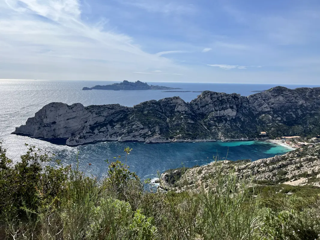 Perspective depuis le haut de la falaise, offrant une vue sur la mer et les calanques de Marseille.