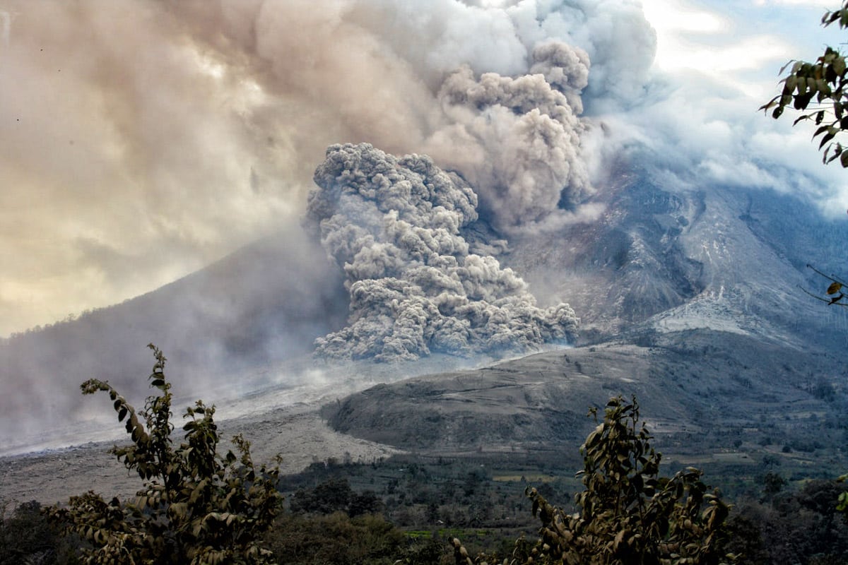 Nuage de cendres dévalant les flancs d'un volcan en éruption.