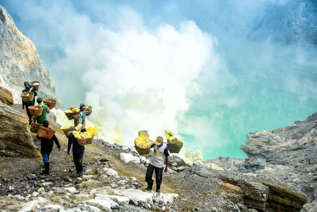 Mineurs transportant du soufre dans le cratère du volcan Kawah Ijen.