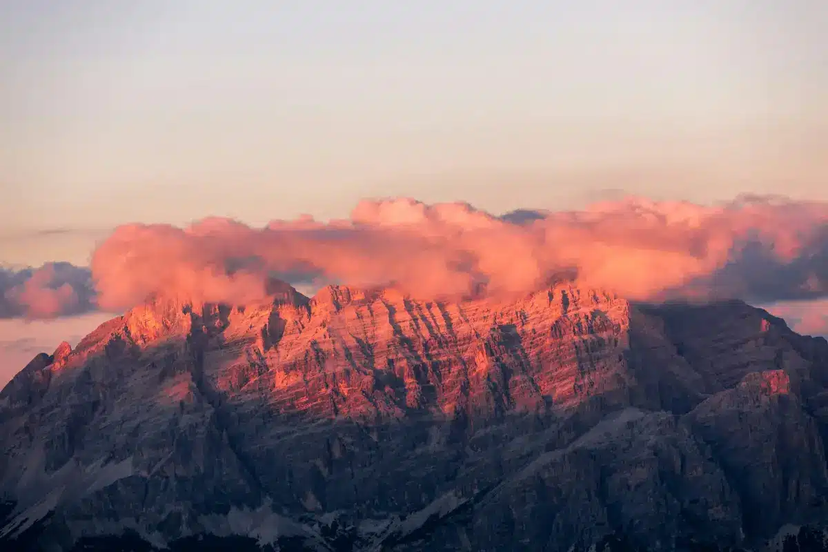 Parois du massif des Dolomites teintées de rose par l’enrosadira au coucher du soleil.