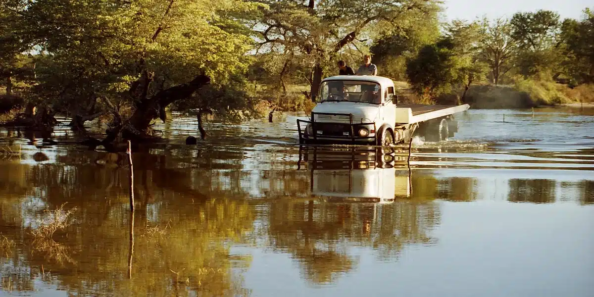 Un camion traverse une rivière inondée dans l'Okavango, l'eau atteignant presque le niveau de la cabine.